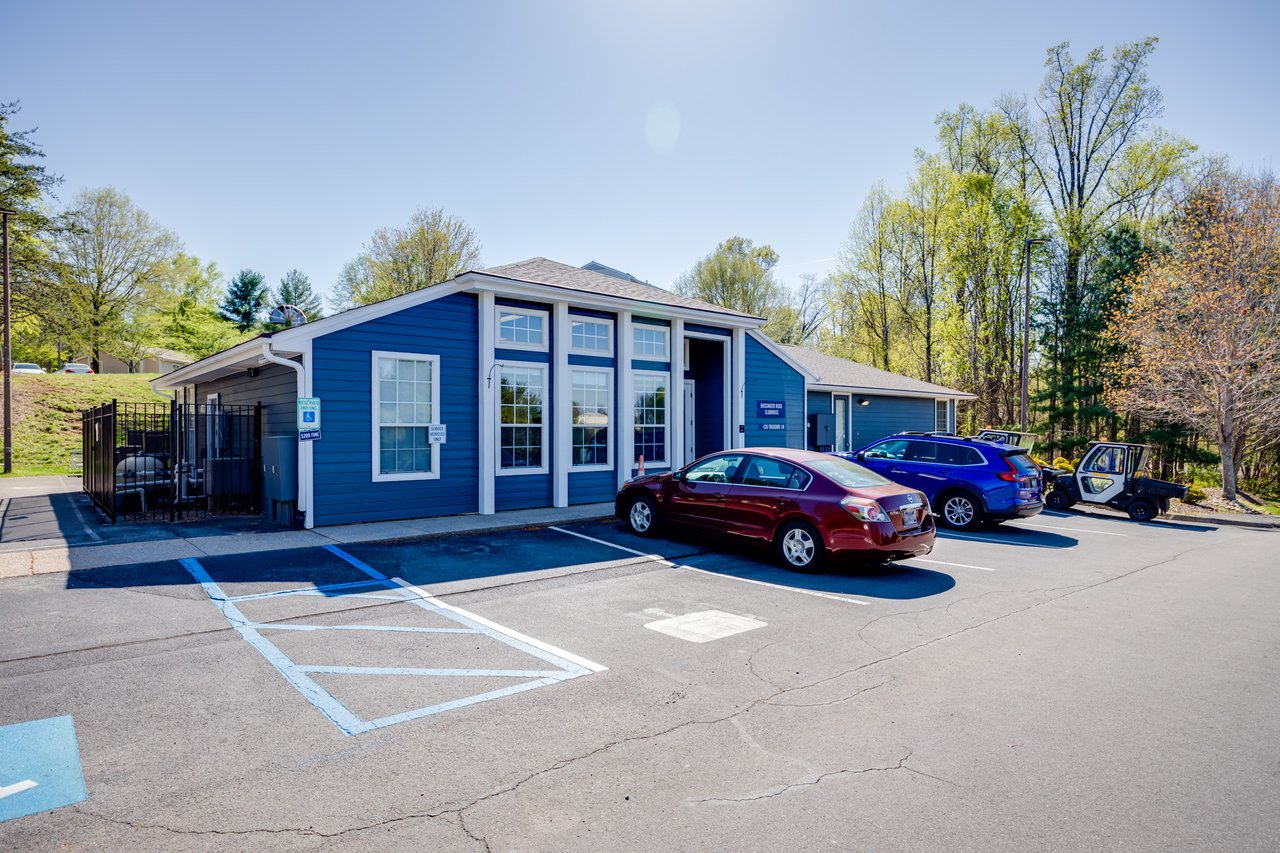 A blue building, the Buccaneer Ridge Clubhouse, sits on top of a hill on a sunny day.