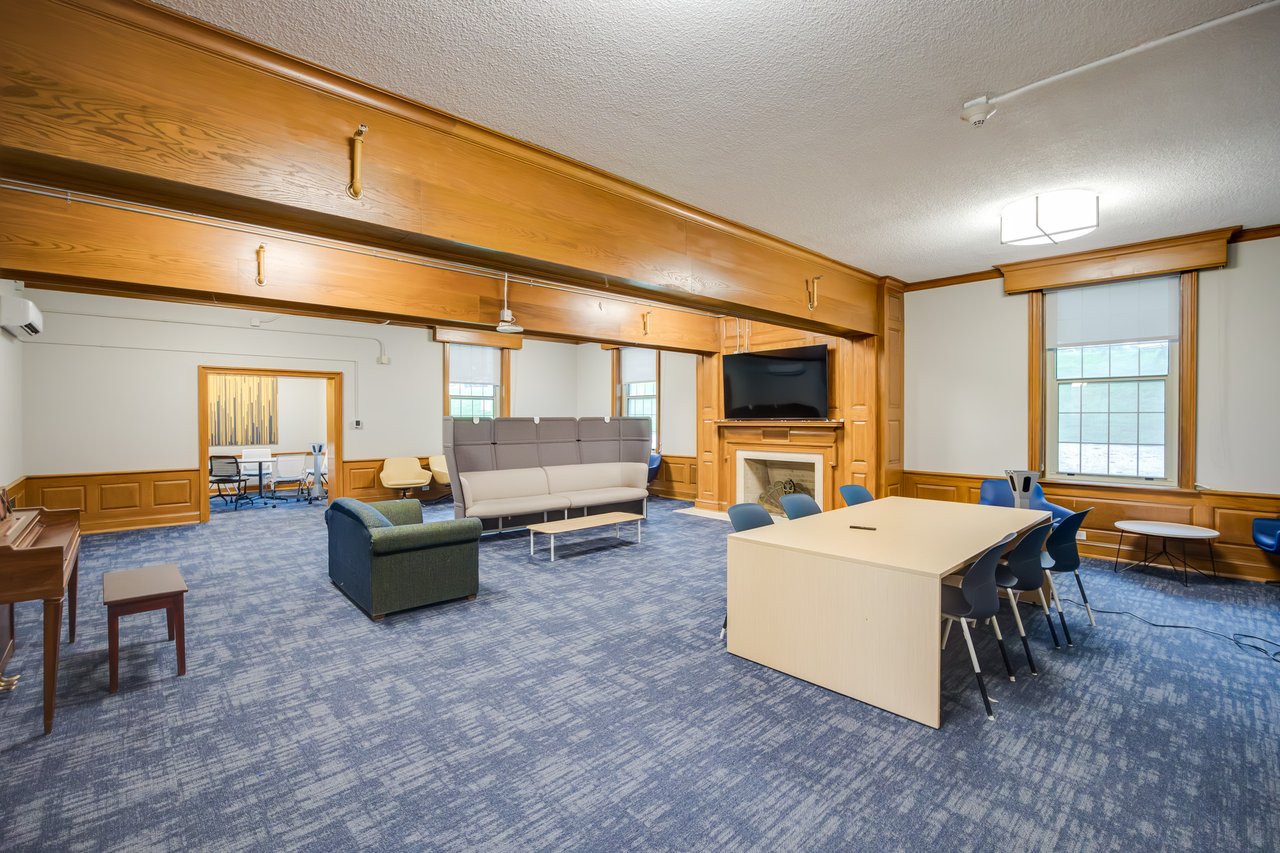 Chairs, couches, and tables fill a room in West Hall that students can hang out in.