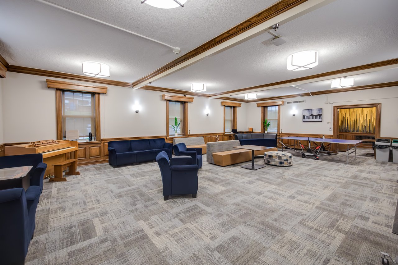Chairs, couches, and a ping pong table fill the student activity room in Dossett Hall.