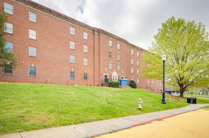 An exterior view of Bonnie S. Luntsford, a brick residential hall with a flowering tree and a yellow sidewalk out front.