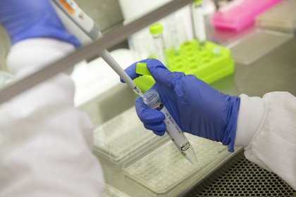 Chemistry lab assistant pipetting in research lab