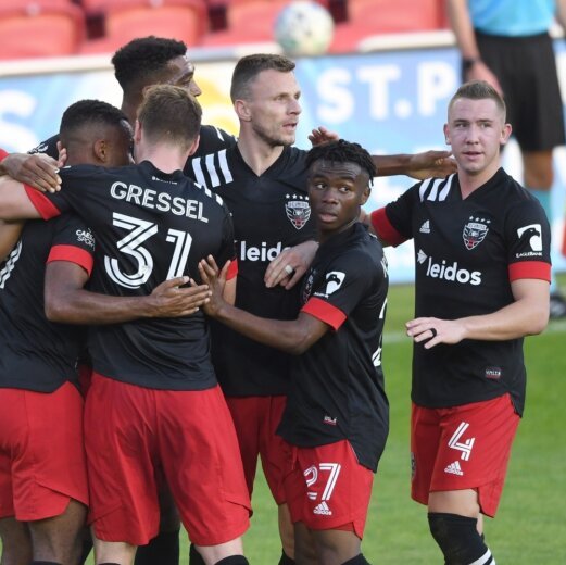 DC United Soccer Team celebrating together on field