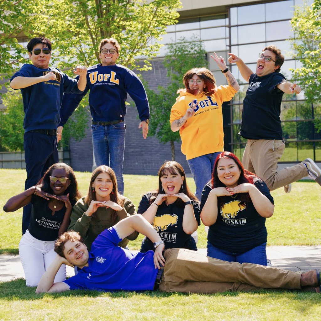 Group of friendly, smiling, staff members wearing University of Lethbridge attire