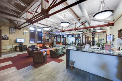 Bright, modern communal space featuring colorful seating, a reception desk, and collaborative work areas.